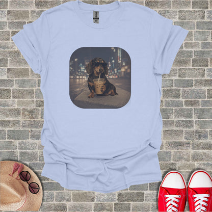 Dachshund wearing sunglasses drinks from a cup with city lights behind it.