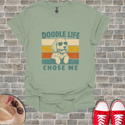 Light green t-shirt with a vintage graphic of a doodle dog wearing sunglasses and the text "DOODLE LIFE CHOSE ME".