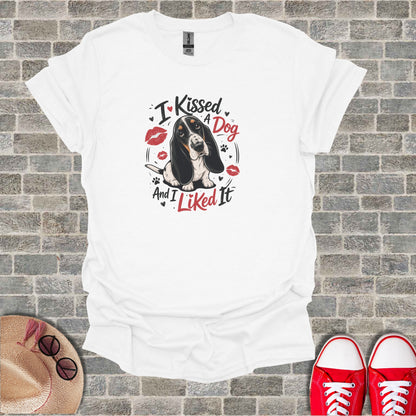 White t-shirt with graphic of a Basset Hound and "I Kissed A Dog And I Liked It" text.