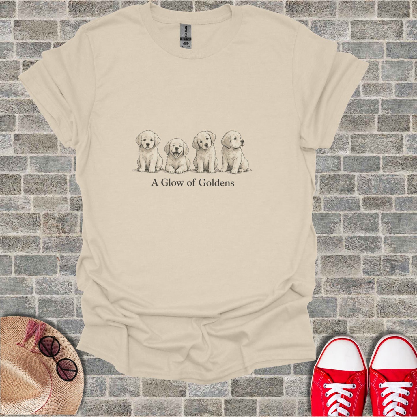 Cream t-shirt with sketch of four golden retriever puppies and "A Glow of Goldens" text.