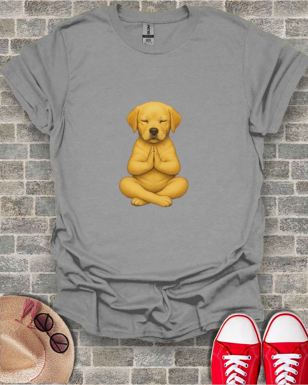 Golden retriever puppy meditating in a lotus pose on a gray t-shirt.