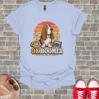 Light blue t-shirt with "OK Boomer" text and retro graphics including a dog, phone, and cassette tape.