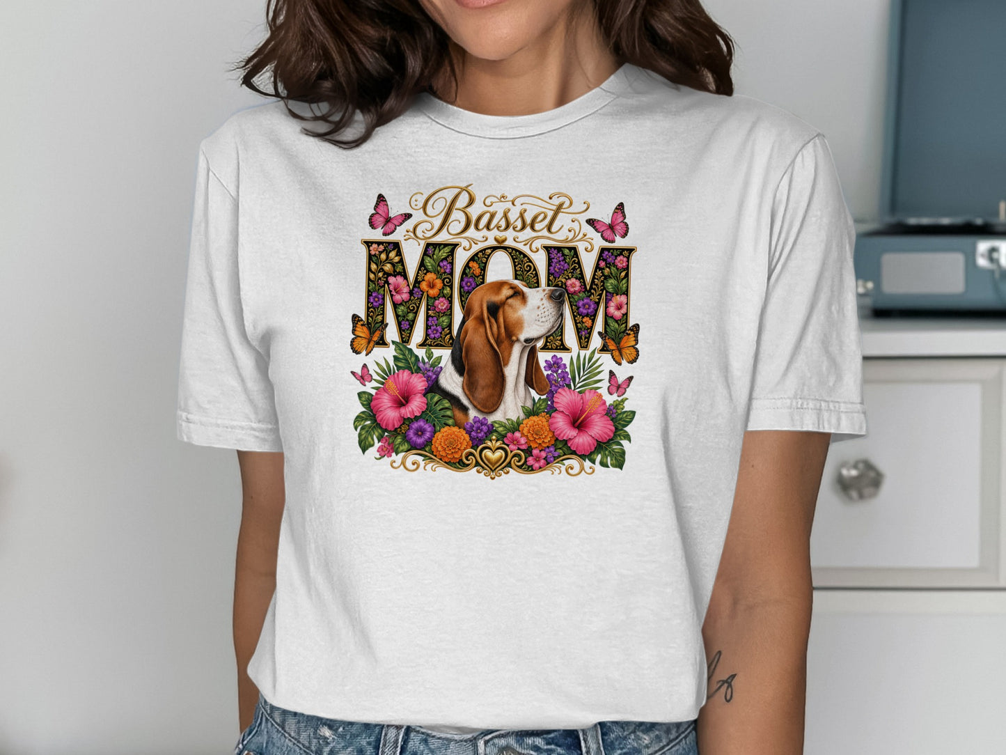 Basset Hound Mom graphic with floral accents and butterflies on white t-shirt.