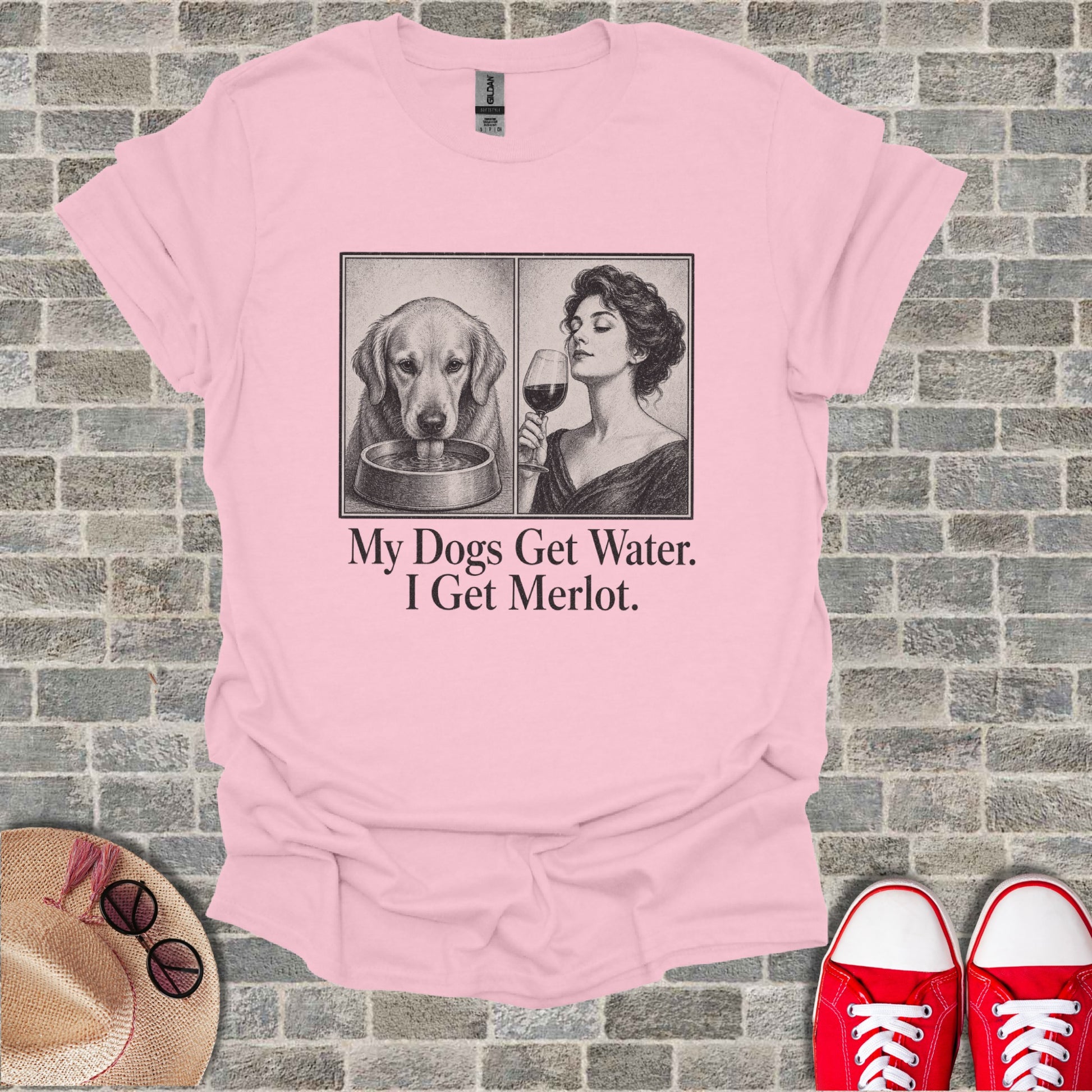 Pink t-shirt with sketch of dog drinking water and woman with wine, text "My Dogs Get Water. I Get Merlot."