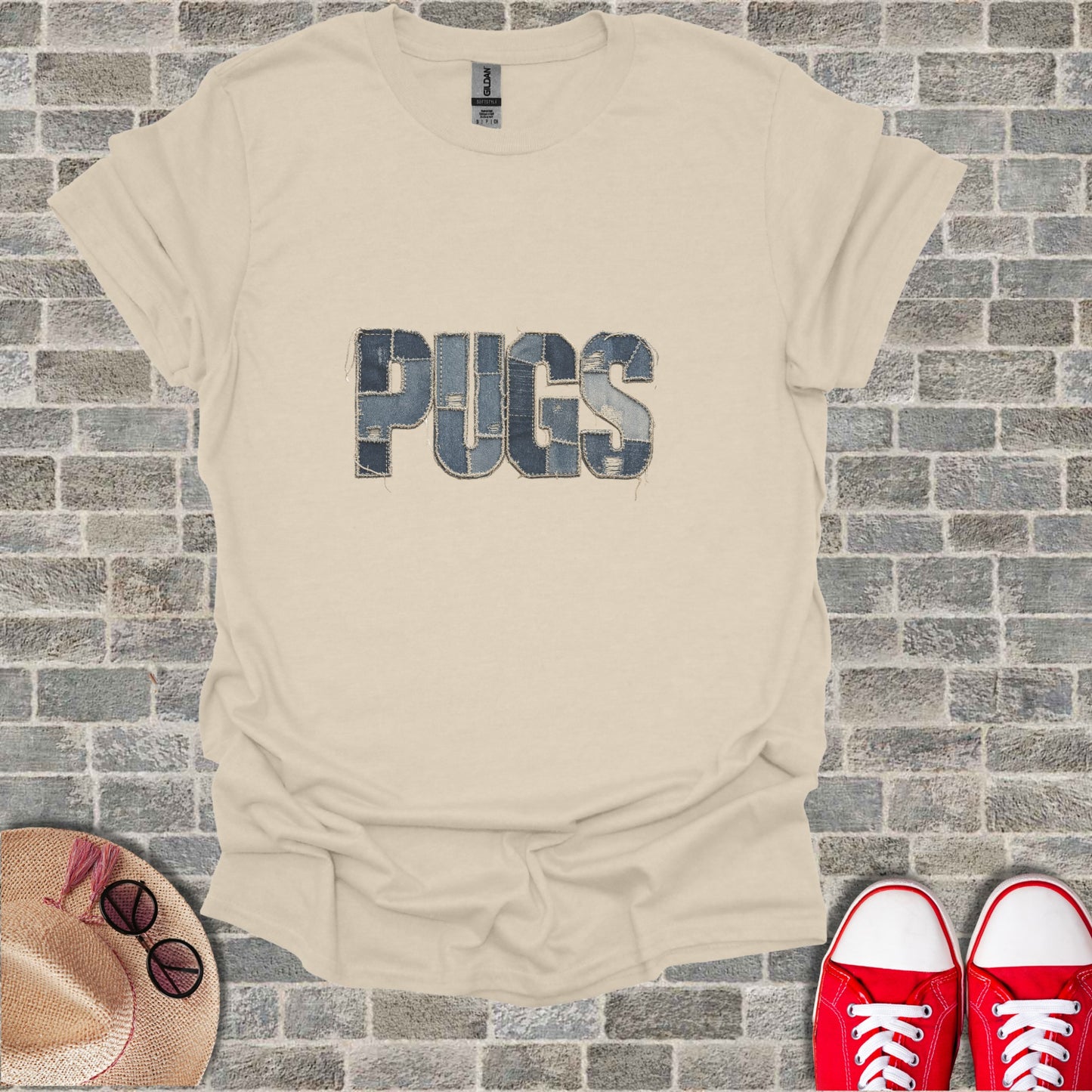 Cream t-shirt with "PUGS" spelled out in denim patches.
