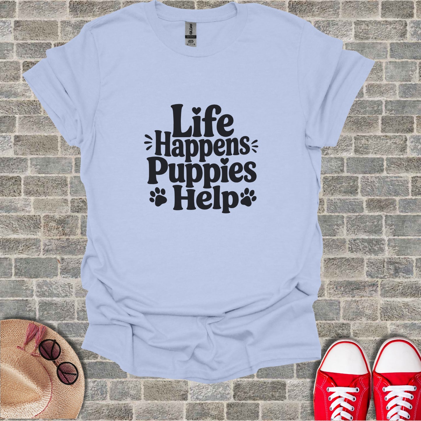 Light blue t-shirt with "Life Happens Puppies Help" text and paw prints.