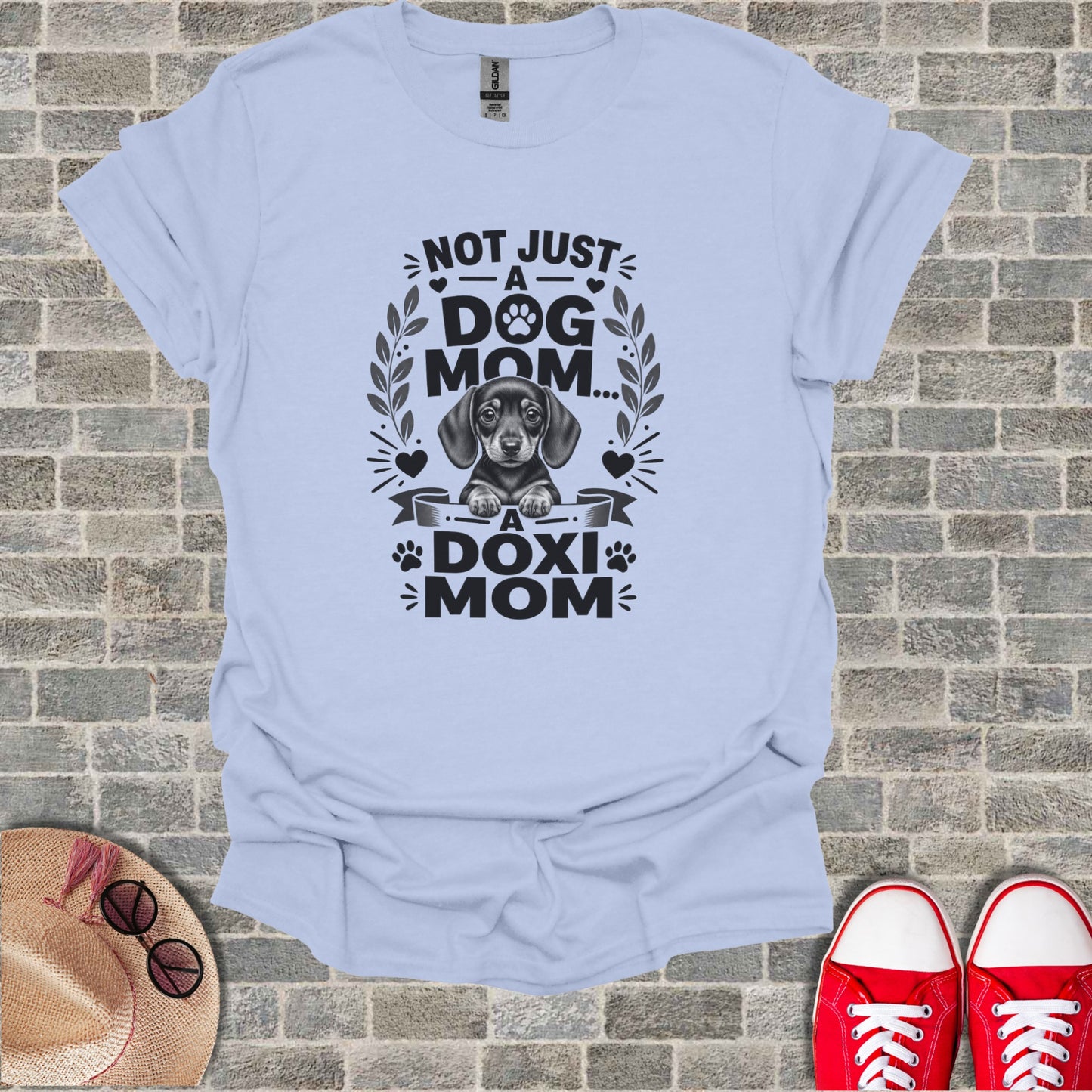 Light blue t-shirt with graphic of a dachshund and text: Not Just A Dog Mom, A Doxi Mom.