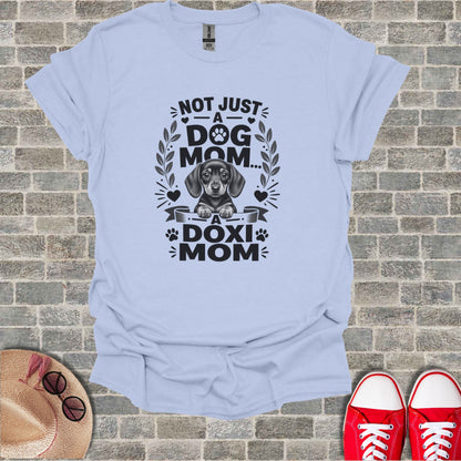 Light blue t-shirt with graphic of a dachshund and text: Not Just A Dog Mom, A Doxi Mom.